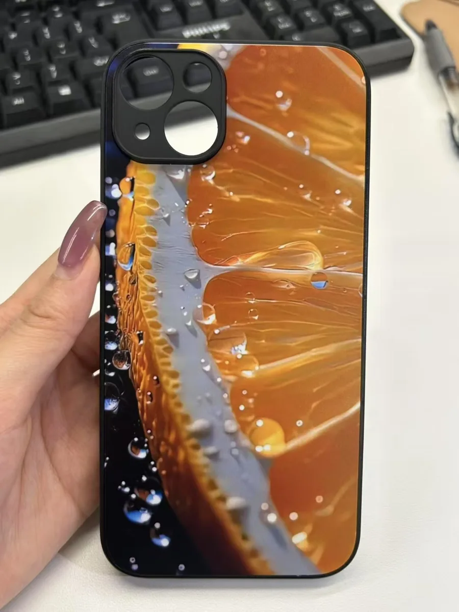 Funda rígida impresa con la fotografía de una naranja, sostenida en la mano